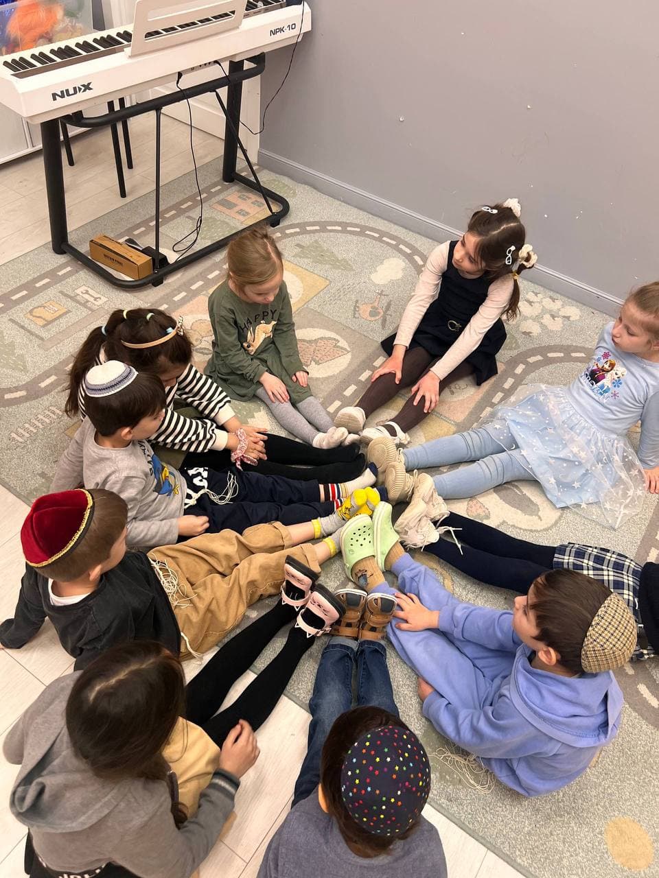 Дети сидят в кругу в игровой зоне