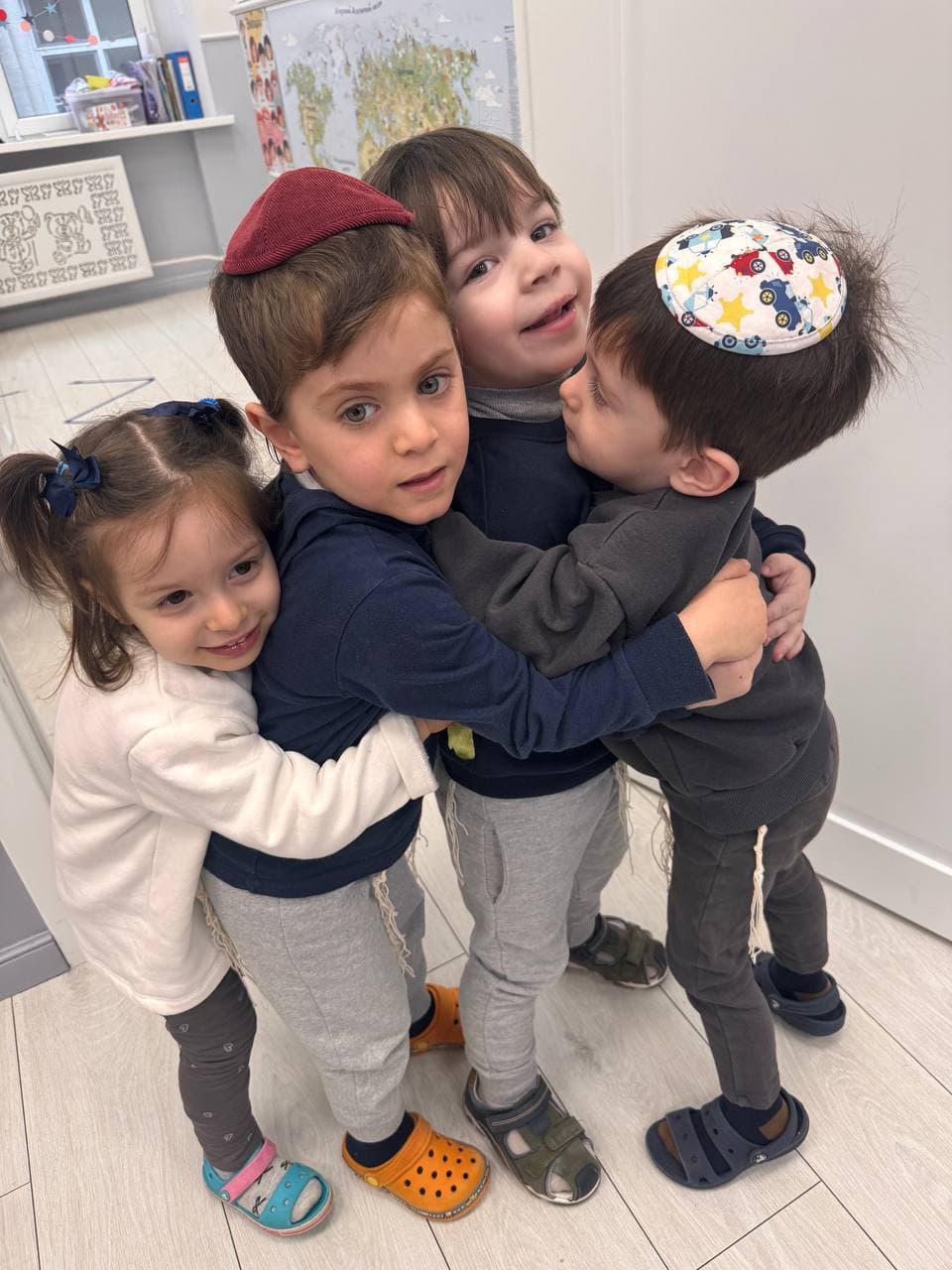 Дети обнимаются в игровой комнате